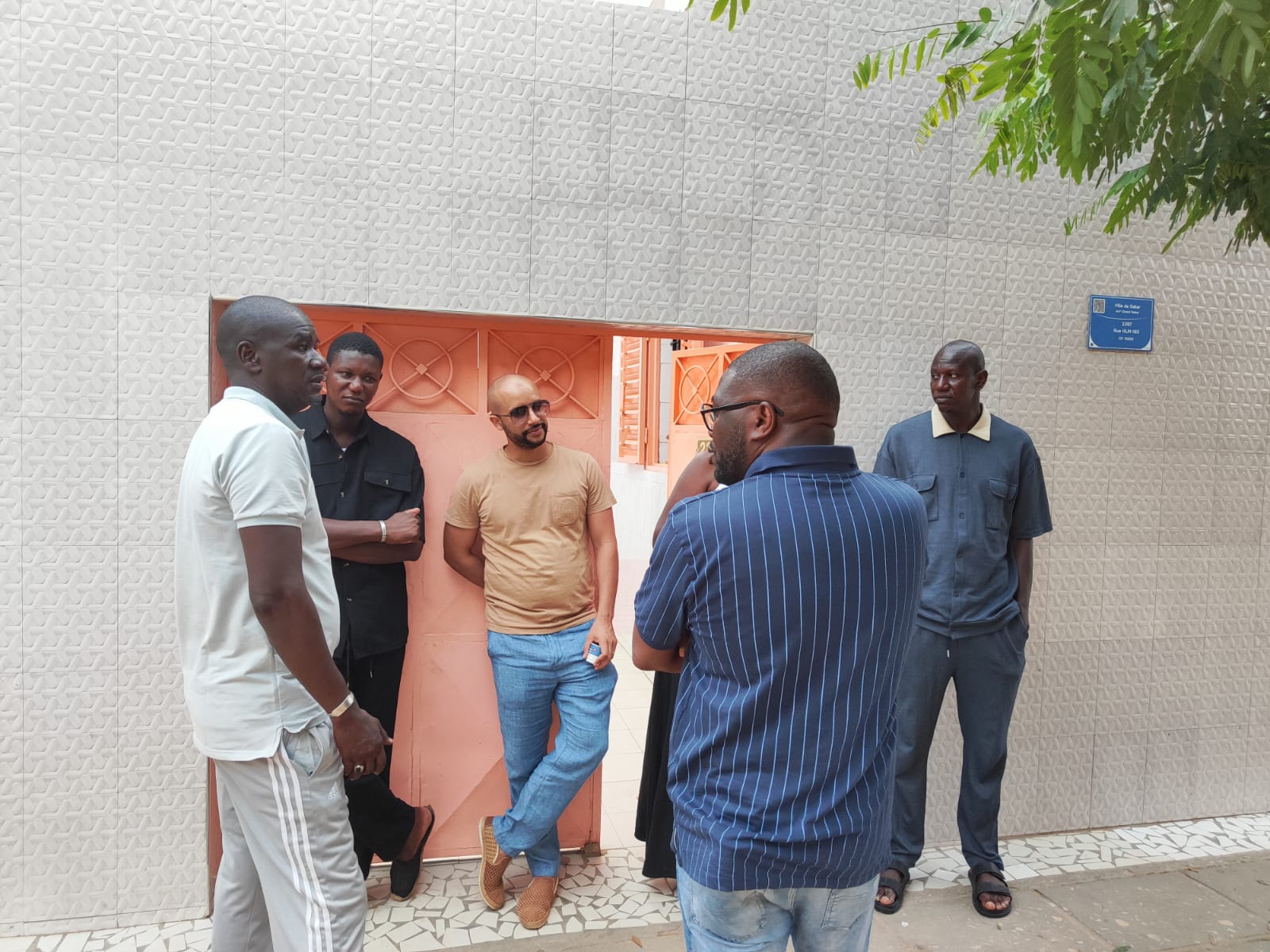 Devant le portail de la maison — Cinq hommes de la famille rassemblés devant un portail orange.