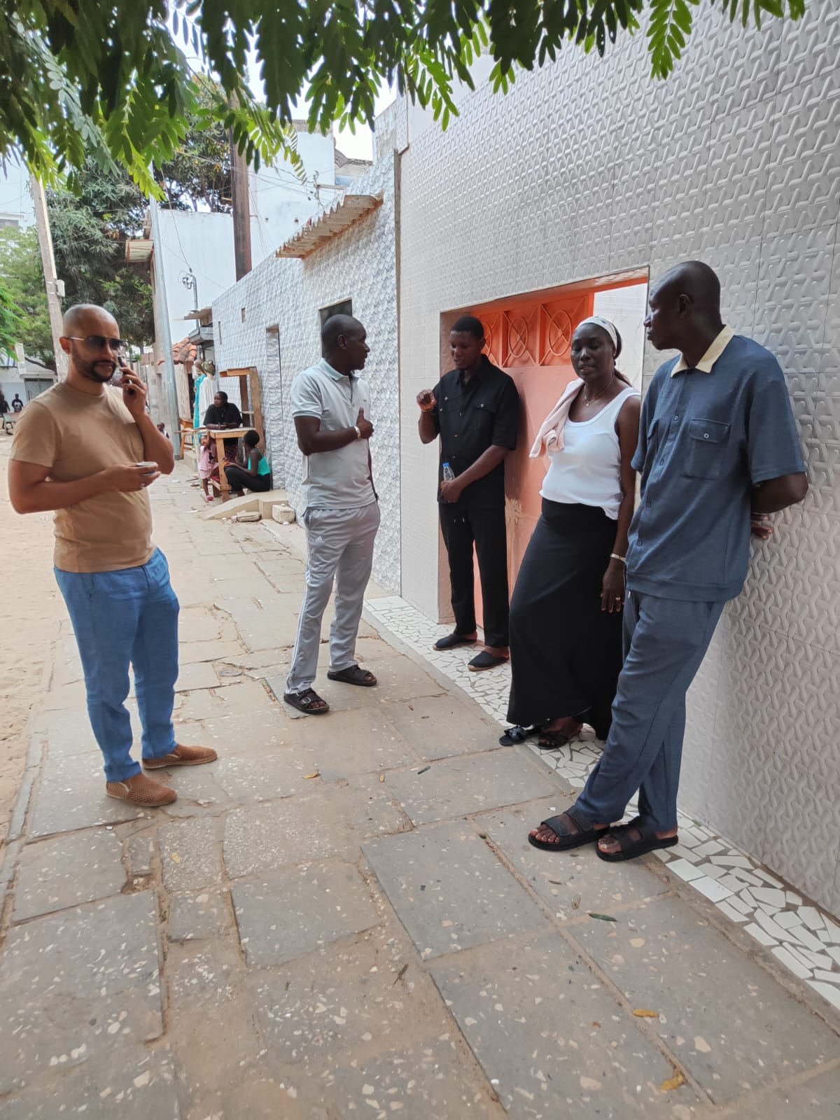 Réunion d'hommes de la famille — Cinq hommes réunis devant un bâtiment, en conversation.